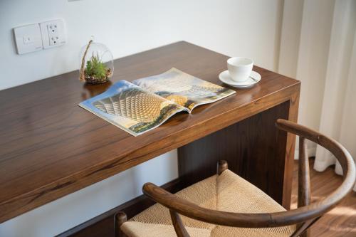 a table with a newspaper and a cup of coffee on it at Duke Casa Apartment in Da Nang