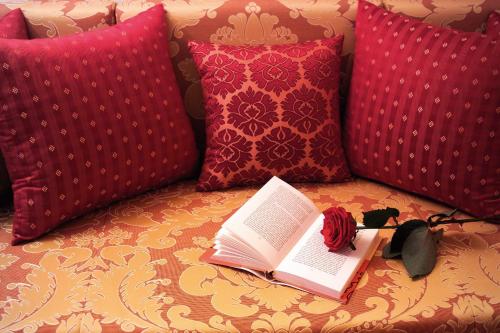 a book sitting on top of a couch with pillows at Hotel Metropol & Spa Zermatt in Zermatt
