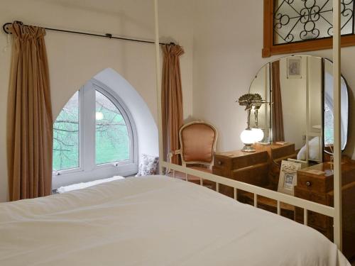 a bedroom with a bed and a window and a mirror at 5 Church Square in Rigg