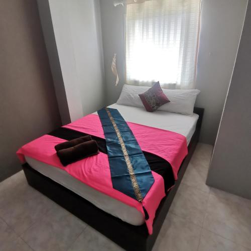 a bedroom with a bed with a pink and black blanket at Haadrin village Fullmoon in Haad Rin
