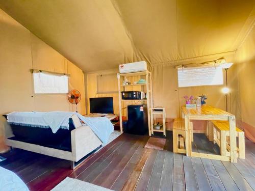 カンポン・ペナリックにあるRembulan Escape - Beachfront safari tentのベッド1台、デスクが備わるテントの客室です。