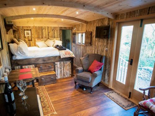 a bedroom with a bed and a chair in a room at The Shepherds Hut At Gowan Bank Farm in Staveley
