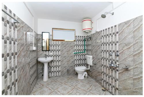 uma casa de banho com um WC e um lavatório em Raybo Hostel em Leh