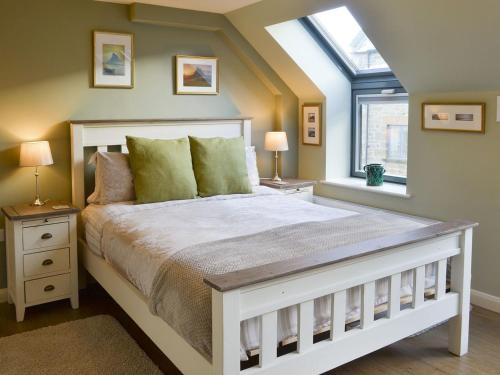 a bedroom with a large white bed with a window at Alnwick Old Brewery Apartment in Alnwick
