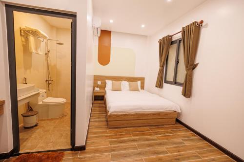 1 dormitorio con 1 cama y baño con aseo en Happy Hotel, en Bạc Liêu