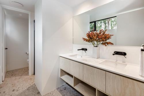 a white bathroom with a sink and a mirror at Kaya Karri in Margaret River Town