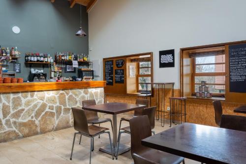 a restaurant with tables and chairs and a bar at El Cuartel de Santa María in Santa María de la Alameda