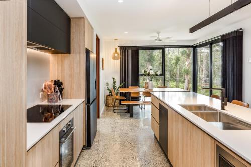 a kitchen with wooden cabinets and a large window at Kaya Karri in Margaret River Town