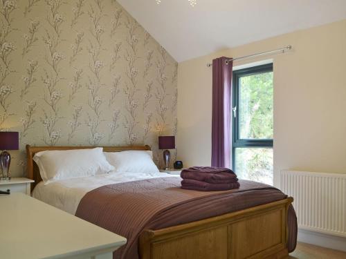 a bedroom with a bed and a window at Sprint Lodge in Burneside