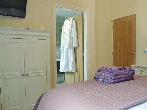 a bedroom with a bed and a robe hanging on a closet at Sprint Lodge in Burneside