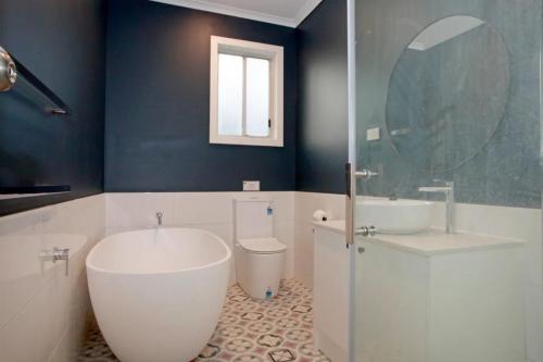 a bathroom with a tub and a toilet and a sink at Sahara Trails House WiFi Air Conditioning Horse Riding and much more in Anna Bay
