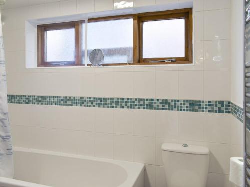 a bathroom with a toilet and a window at Belmont in Longton