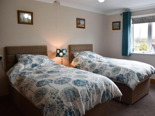 two beds sitting next to each other in a bedroom at Stonehaven Cottage in West Tanfield