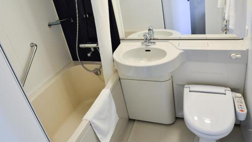 a small bathroom with a toilet and a sink at JR-East Hotel Mets Musashisakaii in Musashino