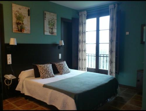 sypialnia z dużym łóżkiem i oknem w obiekcie La Rectoral de Valdedios.Casa rural con chimenea 
