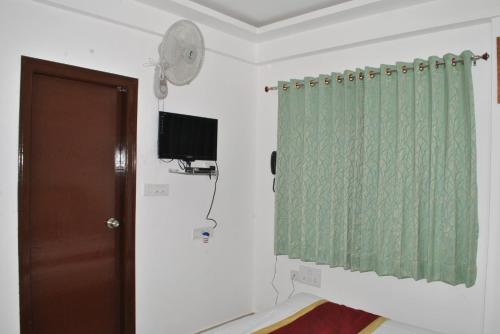 a room with a door and a green shower curtain at HOTEL THE ROYAL PARK in Bangalore