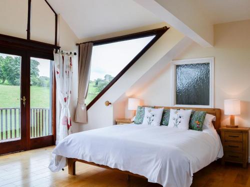 sypialnia z łóżkiem i dużym oknem w obiekcie Pussywillow Cottage w mieście Arlecdon
