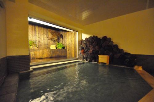 a swimming pool in a room with a bunch of logs at Nikko Tokinoyuu in Nikko