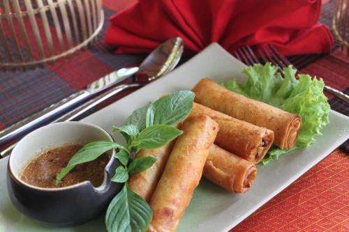 a plate of food with carrots and a bowl of dipping sauce at Mekong Angkor Palace Hotel in Siem Reap