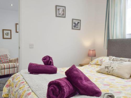 um quarto com toalhas roxas numa cama em The Milk Place em Harby