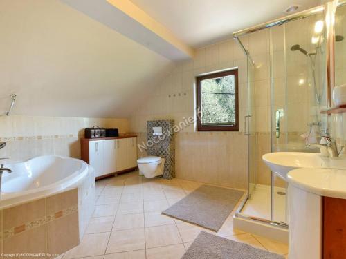 a bathroom with a tub and a shower and a sink at BESKIDIUM - uroczy dom Brenna in Brenna