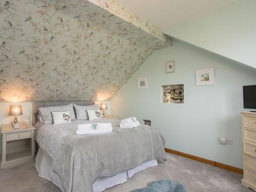 a bedroom with a bed with a floral wallpaper at Hippos Rest in Mow Cop