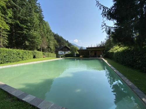 una piscina en el césped con una casa en el fondo en Beim Talschuster, en Scheffau am Wilden Kaiser