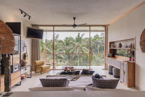 a living room with a fireplace and a large window at Soulshine Bali in Ubud