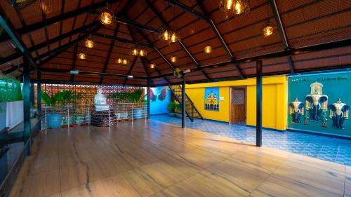 a large room with a wooden floor and yellow and blue walls at Royal Tusker Luxury Service Apartments in Mysore