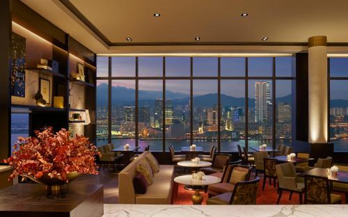 a dining room with a large window overlooking a city at Grand Hyatt Hong Kong in Hong Kong
