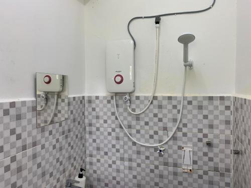 um chuveiro na casa de banho com uma cabeça de chuveiro em MyDusun Chalet, Taiping, Perak, Malaysia em Taiping