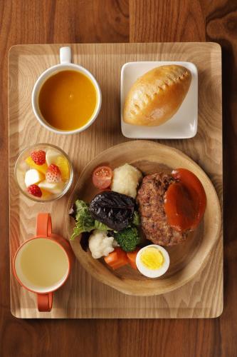 a wooden tray with a plate of food and a cup of tea at Matsumoto Jujo in Matsumoto
