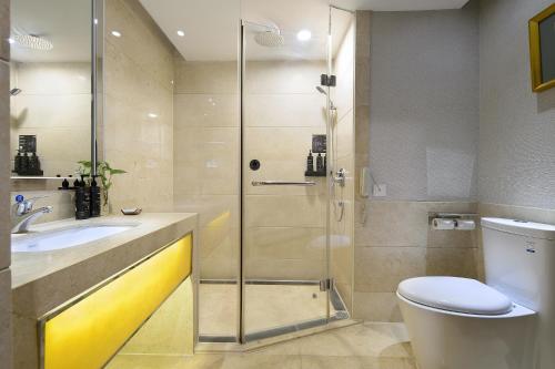 a bathroom with a shower and a toilet and a sink at Foshan Rezen Select Pasonda Hotel in Foshan