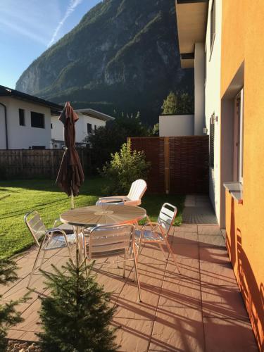 a patio with a table and chairs and a mountain at Appartement Schusternagele in Amlach