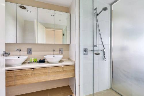 a bathroom with two sinks and a shower at Darwin's Dazzler - Your Ultimate Waterfront Escape in Darwin