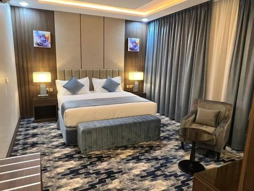 a hotel room with a bed and a chair at فندق امان أبها - المحالة in Abha