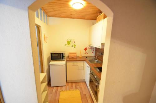 eine Küche mit einem weißen Kühlschrank und einer Mikrowelle in der Unterkunft Apartment Alena include Jokercard only Summer in Saalbach-Hinterglemm