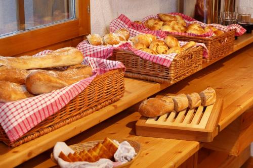 una mesa con varias cestas de pan y pasteles en Hôtel du Bourg, en Valmorel