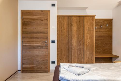 a bedroom with a bed and a wooden door at Appartamento Tobià in Pozza di Fassa