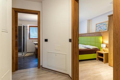 a bedroom with a bunk bed and a bathroom at Appartamento Tobià in Pozza di Fassa