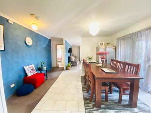 a dining room with a wooden table and a blue wall at ENTIRE HOME IN WERRIBEE,BEST POSSIBLE LOCATION YOU CAN FIND in Werribee