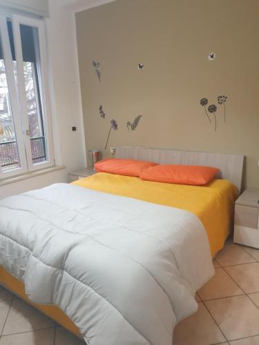 una camera con letto e lenzuola bianche e arancioni di Romeo1 a Gallarate