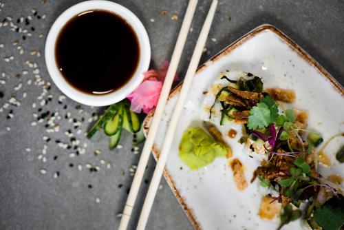 a plate of food with a cup of coffee and chopsticks at The Capital Trilogy Menlyn Maine in Pretoria