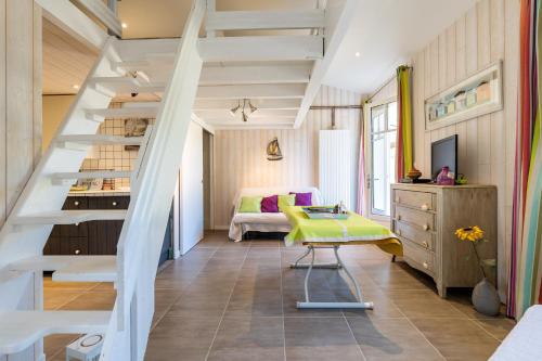 sypialnia ze schodami i żółtym stołkiem w pokoju w obiekcie Studio Plage Petit Piquey w mieście Lège-Cap-Ferret