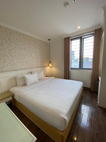 a bedroom with a large white bed and a window at Khách Sạn A83Hotel in Hanoi