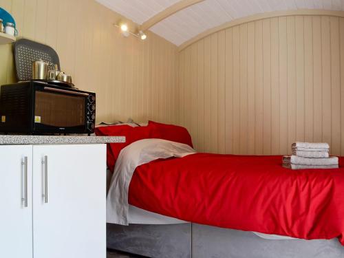 a bedroom with a bed with a red blanket at Mountain View in Llanthony