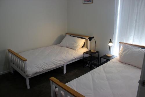a bedroom with two beds and a lamp on a table at Anglers Rest at Sunderland Bay in Sunset Strip