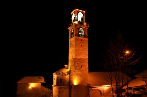 a building with a clock tower at night at Residence Trompe-L'oeil in Champoluc