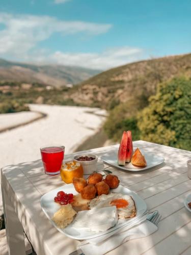una mesa con platos de comida en una mesa con vistas en Guesthouse Lord Byron, en Tepelenë