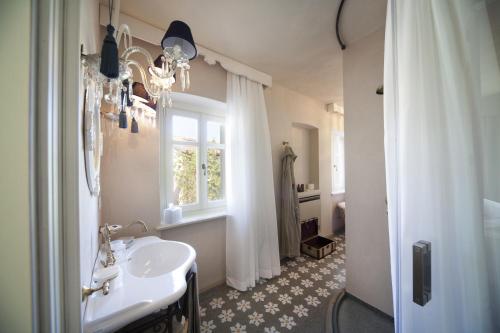 a bathroom with a sink and a window and a shower at Palas Cerequio in La Morra